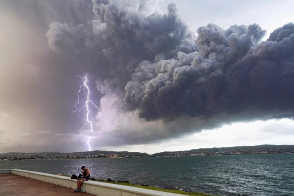 Lightning strikes through smoke rising from an oil depot fire in Matanzas province on August 9 - Photo: REUTERS